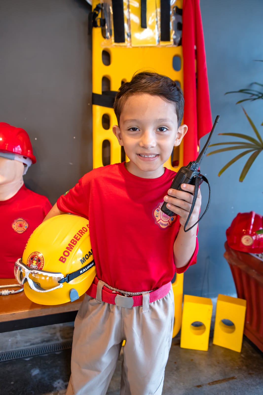 Bombeiro mirim com rádio comunicador e capacete de resgate